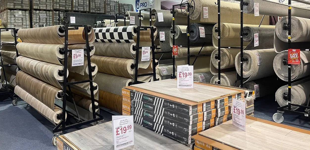 Inside the Flooring Factory Outlet showroom in Croydon, presenting a diverse selection of wood flooring, sheet vinyl flooring, carpet rolls, and flooring accessories.